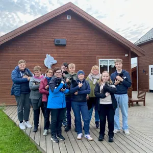 En gruppe mennesker som poserer for et bilde foran et hus
