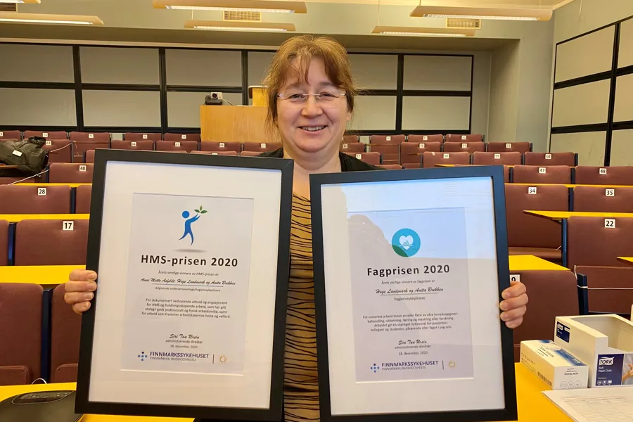 Hege Lundmark viser frem prets diplomer.
