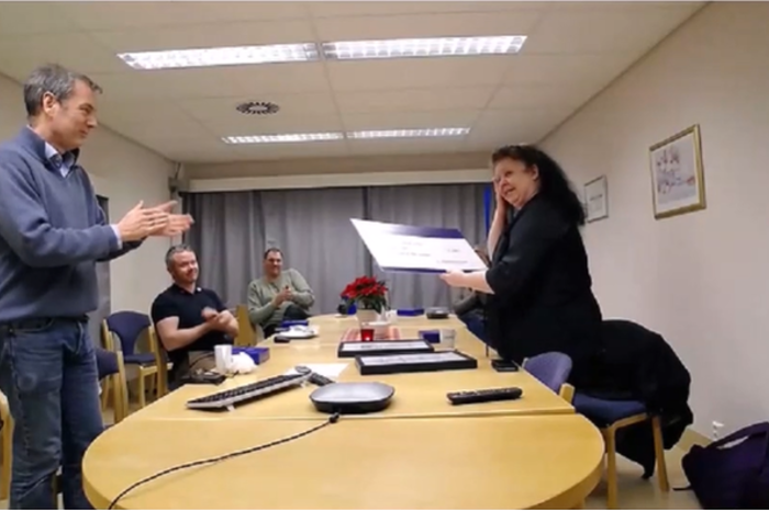 En mann og en kvinne som snakker med en mann som sitter ved et bord
