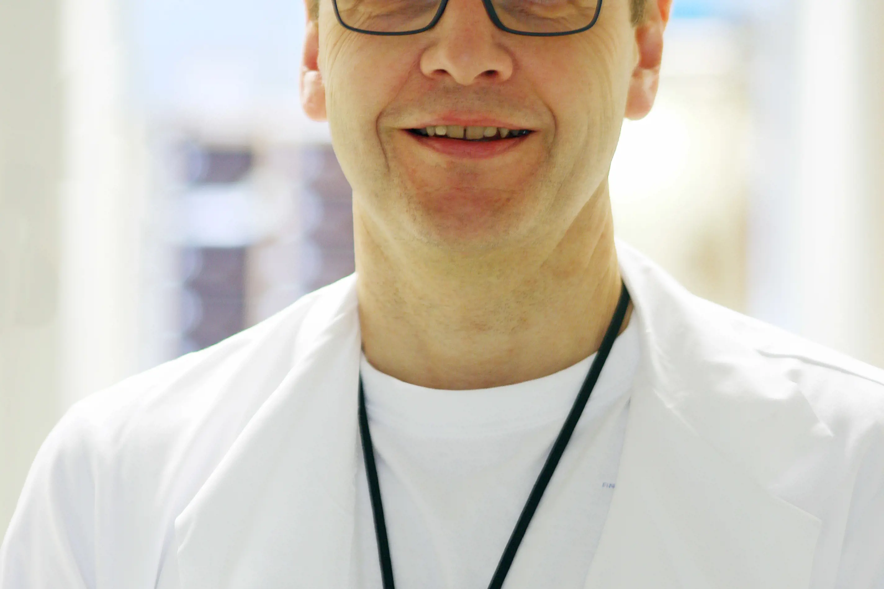 En mann med briller og hvit skjorte