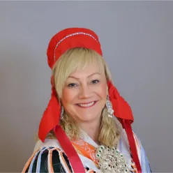 A person wearing a red and white headdress and smiling