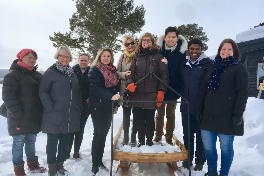 En gruppe mennesker som poserer for et bilde i snøen